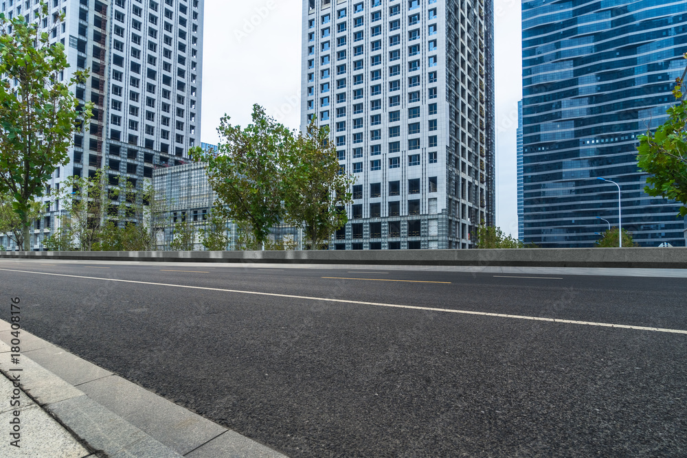 empty road and modern office block buildings against sky, china.