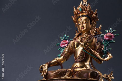 Bronze figurine of a green Tara with copyspace.