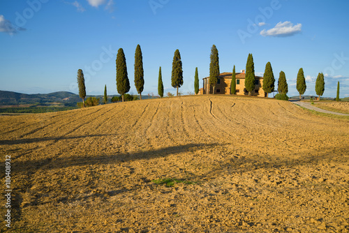 The harvested field and the old villa on a sunny September day. Tuscany  Italy