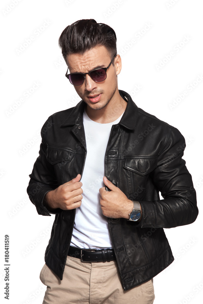 Fototapeta premium cool young fashion man pulling leather jacket's collar