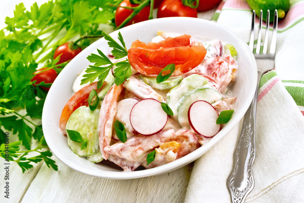Salad from fresh vegetables with greens in plate on board Salad from fresh vegetables with greens in plate on board