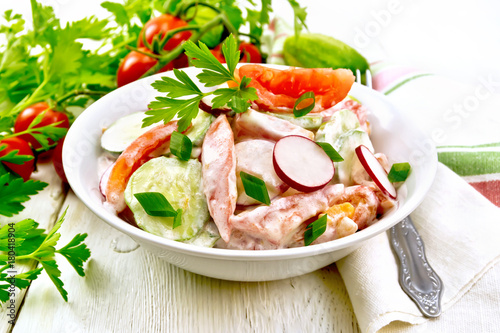 Salad from fresh vegetables and greens in plate on board