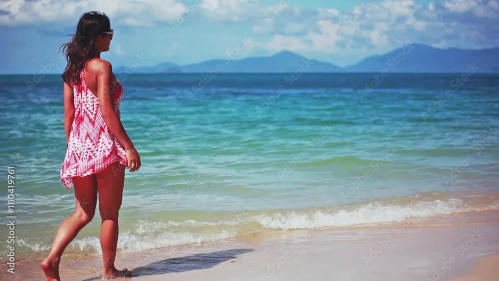 Brunette young woman walking on a tropical beach with amazing blue color the sea. 1920x1080 Brunette young woman walking on a tropical beach with amazing blue color the sea. 1920x1080