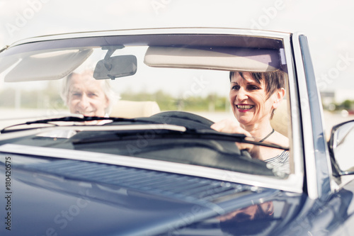 Senior Couple Driving A Convertible Classic Car