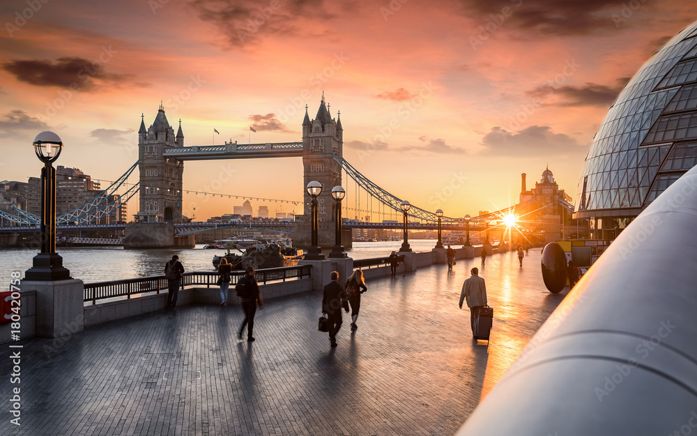 Obraz premium Godziny szczytu w Londynie o wschodzie słońca: ludzie biegną do pracy na Tower Bridge