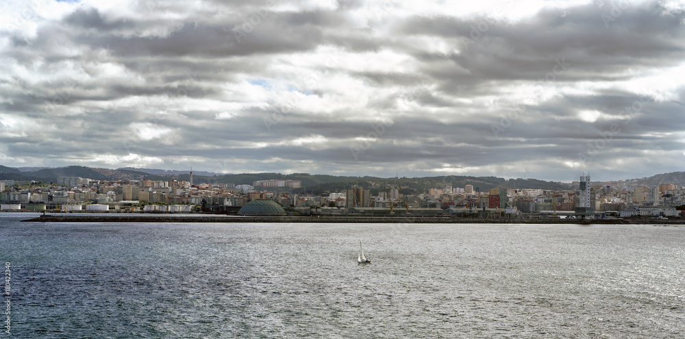Panoramic view of the city of La Coruna on the Atlantic coast of Galicia (Spain). Sky with dark clouds and sun reflections
