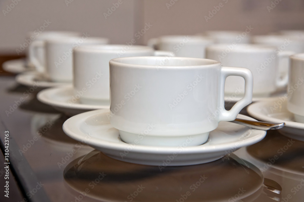Close up dirty coffee cup and spoon setting on white saucer and wooden table after drinking in the morning in vintage style. cup Close up dirty coffee cup and spoon setting on white saucer and wooden table after drinking in the morning in vintage style. cup