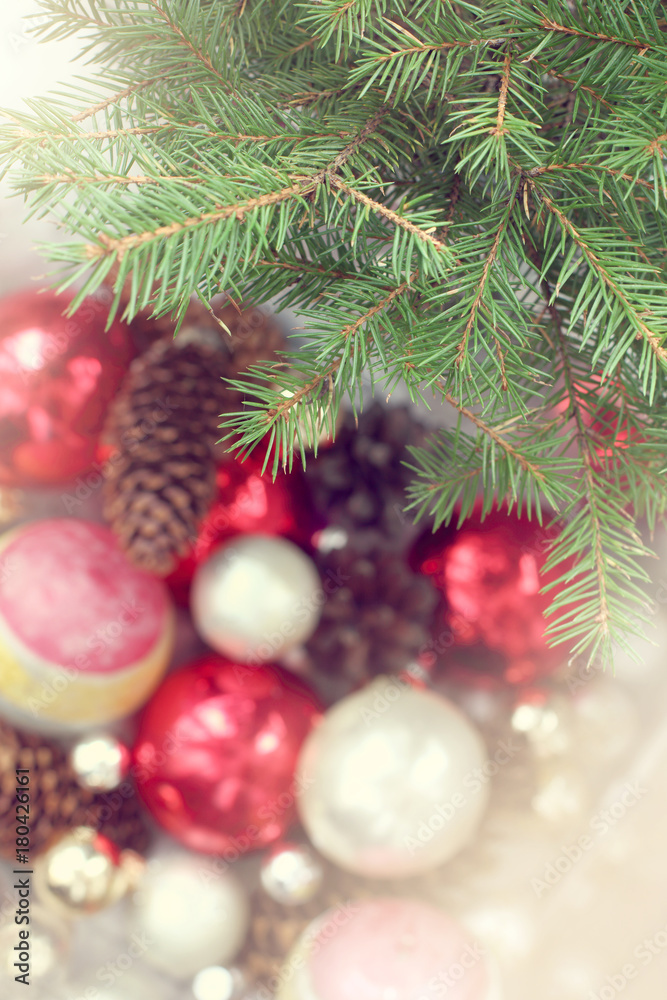 Obraz premium Christmas accessories for holiday/ green branches of real Christmas tree on background of blurred silhouettes of ornaments