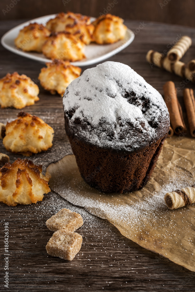 Chocolate muffin sprinkled with powdered sugar. Homemade cookies. Selective focus.