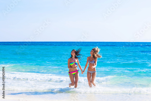 Women in bikni run to beach