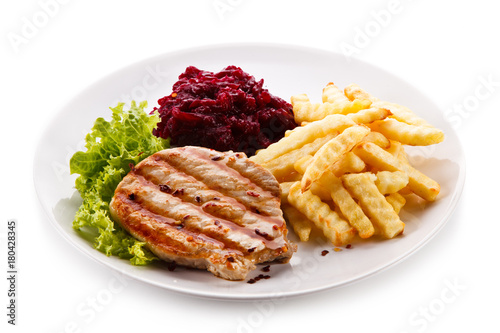 Grilled steak, French fries and vegetables on white background