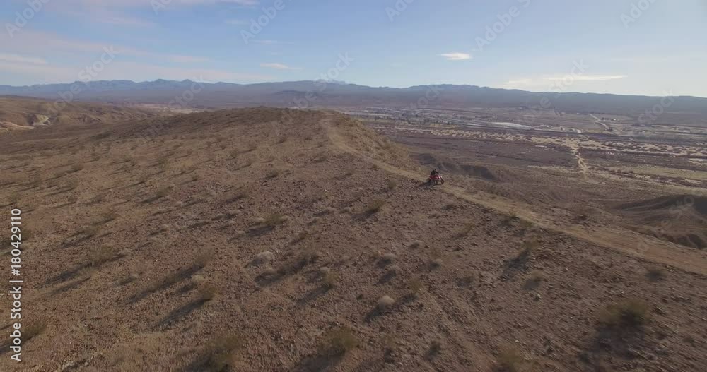 Aerial shot of man riding his ATV on a desert ridgeline
