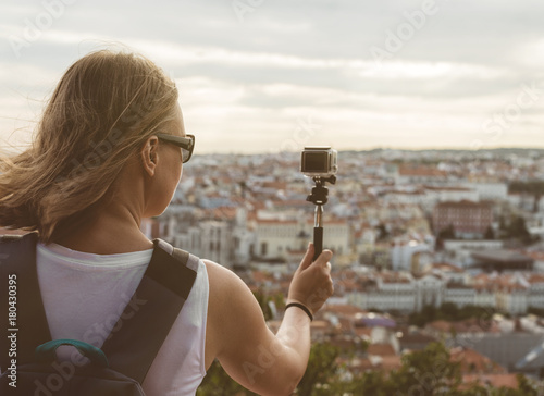 Woman traveller with camera shooting video.