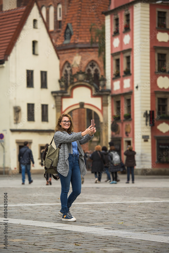 Fototapeta premium Podróżniczka robi selfie na placu europejskiego miasta