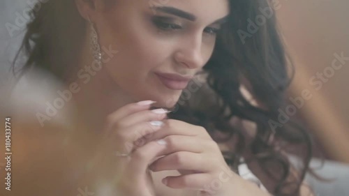 Beautiful bride puts on earring getting ready for wedding