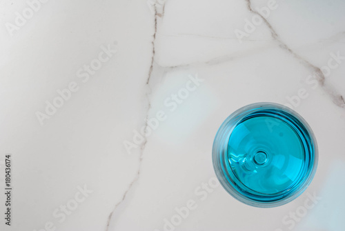 Alcohol drink. Glasses with trendy blue wine, on white marble table background. Copy space top view