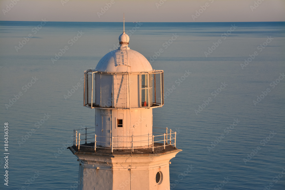 Sea lighthouse close-up against the sea and horizon