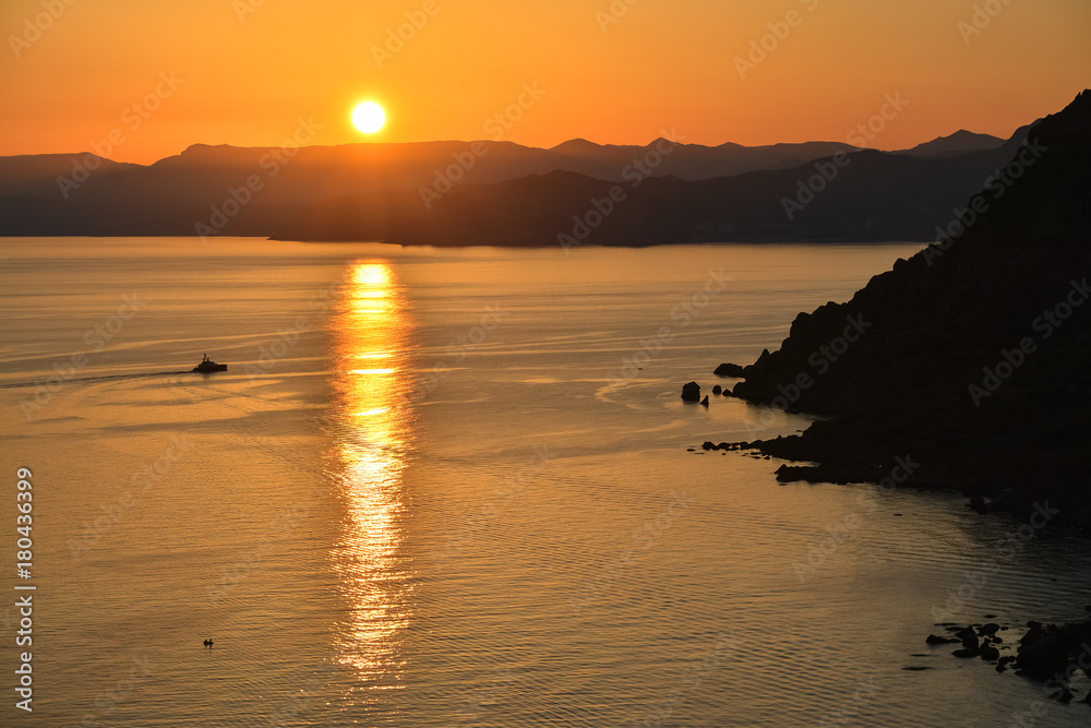 Rocks on the sea shore in the rays of sunset Rocks on the sea shore in the rays of sunset