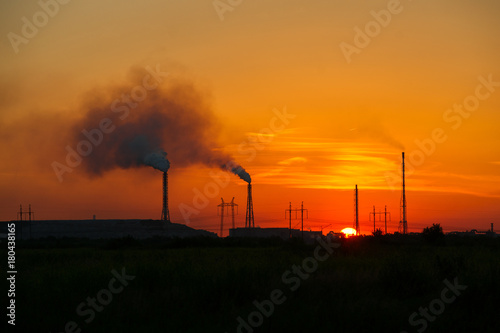 Toxic factory smoke causes harm to the environment at sunset