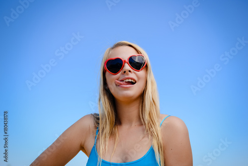 Attractive sexy blonde woman wear sunglasses posing in sunshine countryside copyspace outdoors background. Close up portrait of one caucasian joyful girl looking positive, bright emotional freshness © gorosi