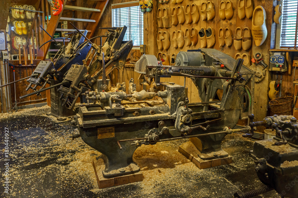 traditional old clog making machine in workshop with wooden shoes on display traditional old clog making machine in workshop with wooden shoes on display