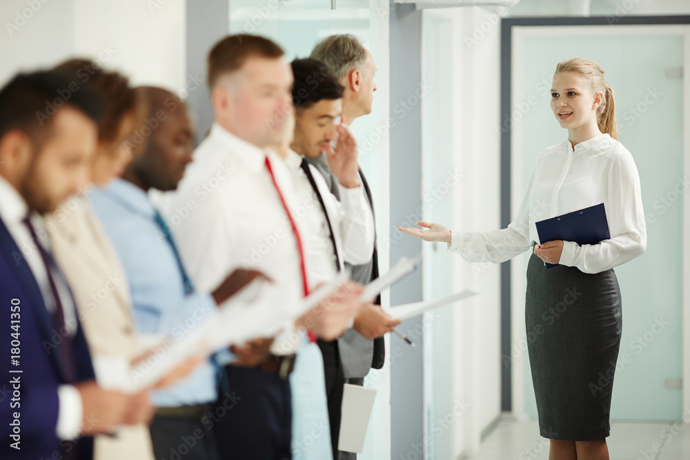 Young secretary inviting next candidate for interview to boardroom Young secretary inviting next candidate for interview to boardroom