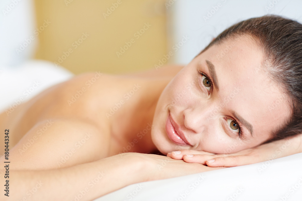 Young serene brunette having rest in day spa salon before massage Young serene brunette having rest in day spa salon before massage