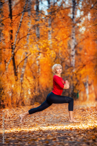 beautiful woman doing yoga outdoors in autumn