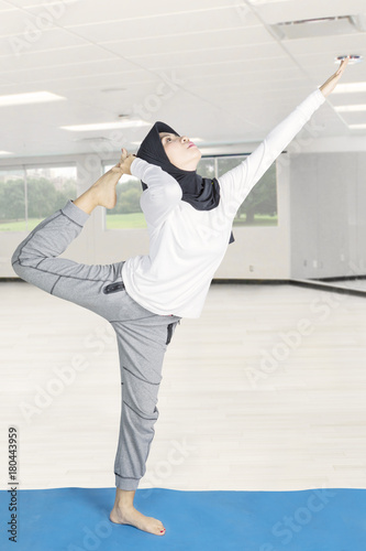 Muslim woman doing yoga at gym