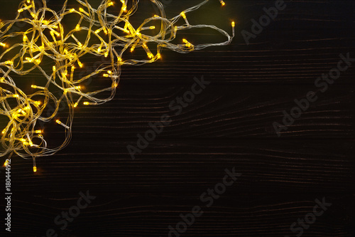 Christmas lights border on dark wooden background