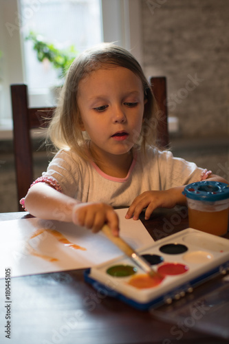 A little girl drawing with watercolors
