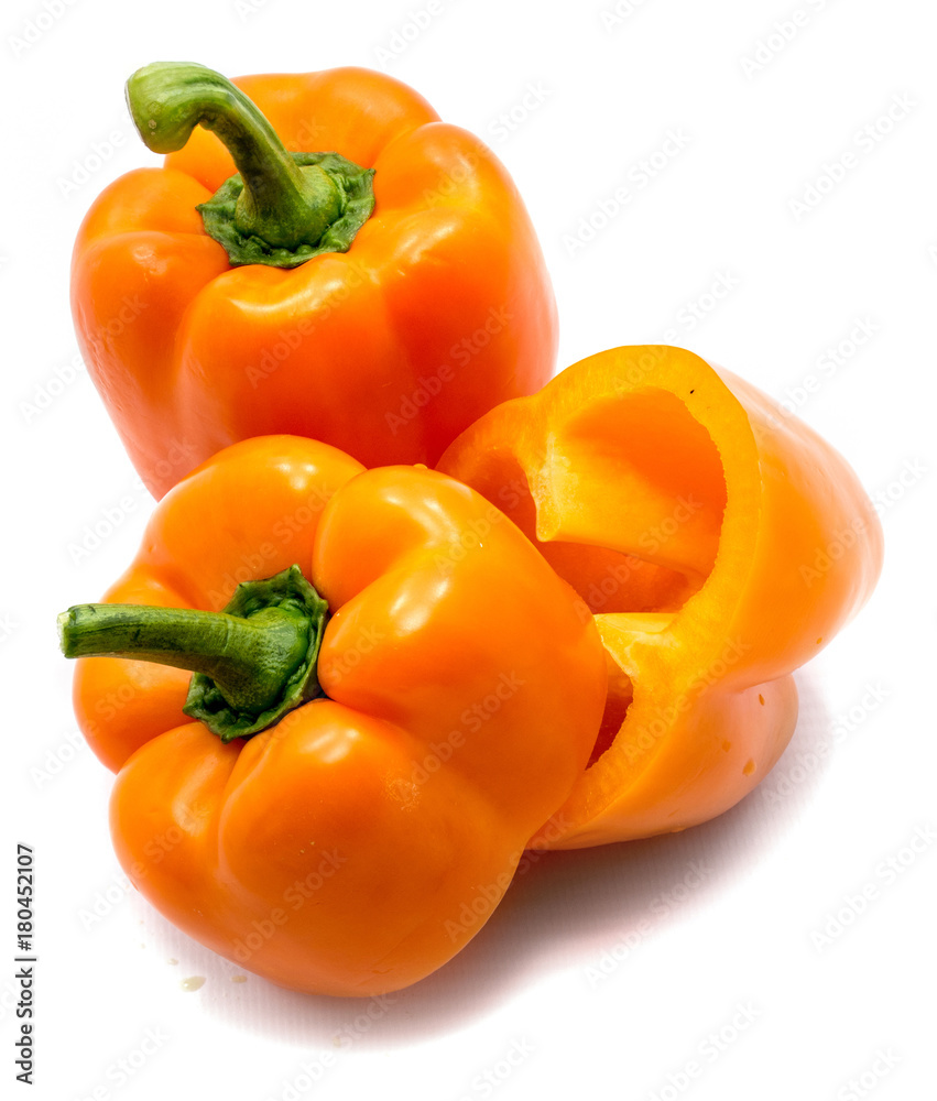 Group of two orange peppers, one whole and one cut pepper isolated on white background. Group of two orange peppers, one whole and one cut pepper isolated on white background.