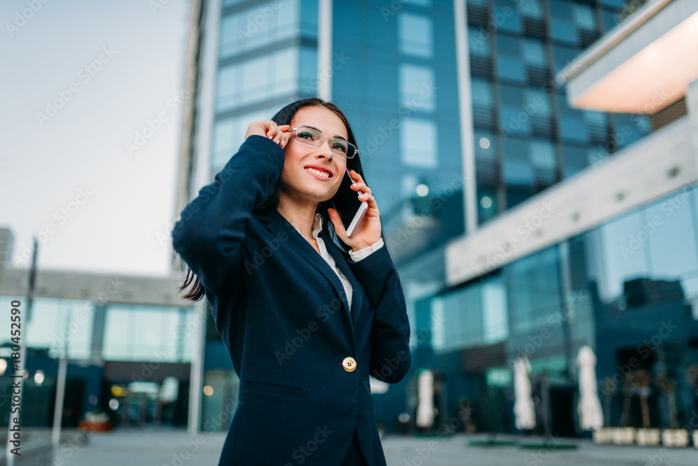 Fototapeta premium Businesswoman in suit talks by phone outdoor