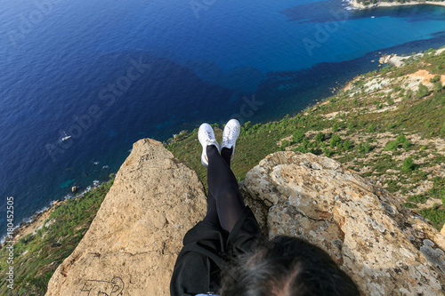 Promeneuse en basket les pieds dans le vide depuis le cap canaille au-dessus de Cassis, Provence photo