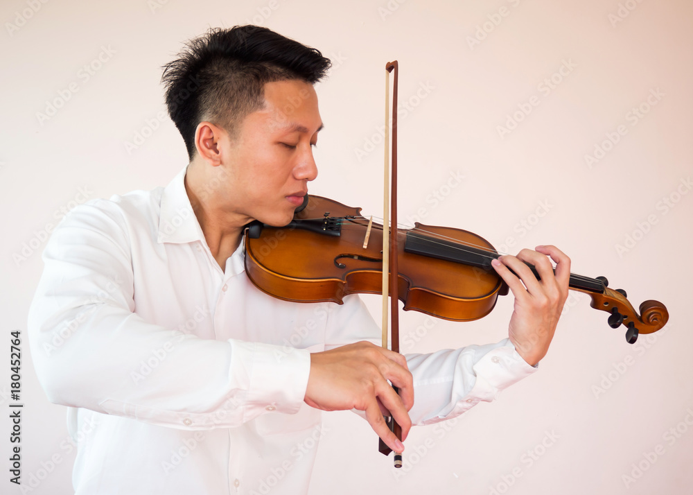 Young Asian man playing violin. Classical music instrument. String equipment. Art and music portrait background.