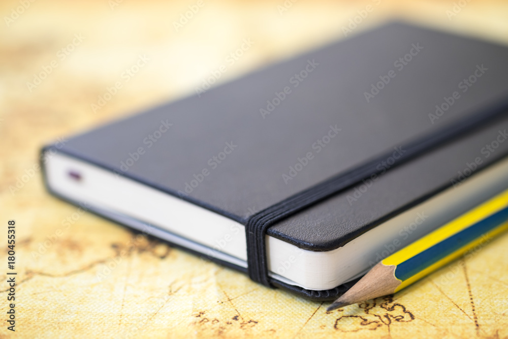 Travel Concept. Close up of black notebook with pencil on world map. Travel Concept. Close up of black notebook with pencil on world map.