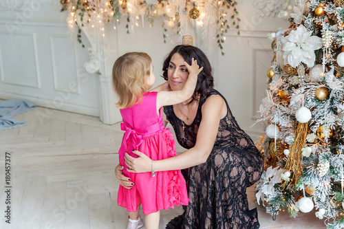 mother and daughter near a Christmas tree photo