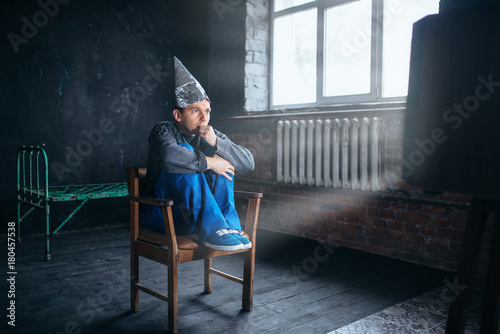 Afraid man in tinfoil helmet watches TV 