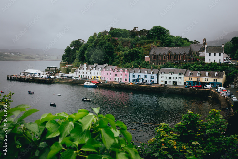 The row of pastel coloured houses in Portree harbour in gloomy weather