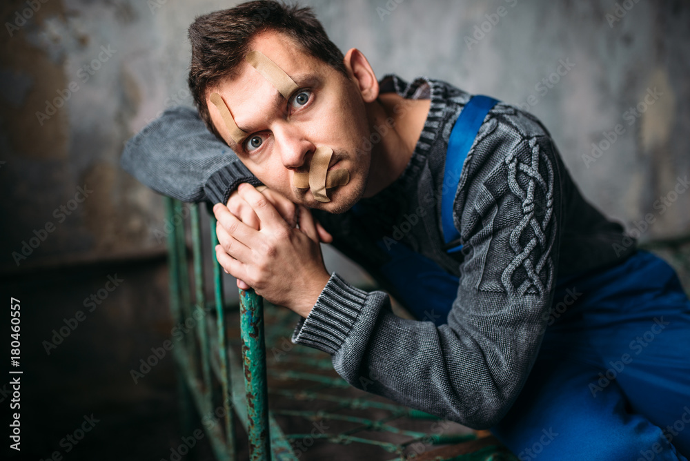 Madman, eyelids and mouth sealed with plaster Madman, eyelids and mouth sealed with plaster