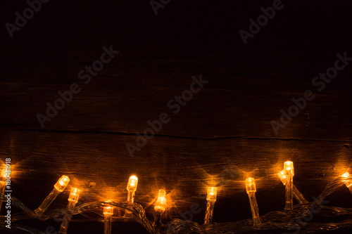 Electric lighted garland on wooden background