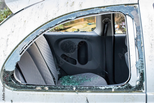 Broken car window with smashed glass all over the rear seat