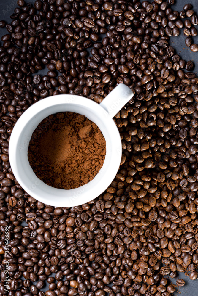 Mug of coffee and grains all around. View from top to flat lying.