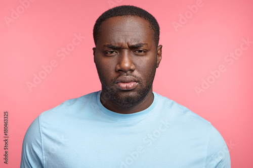 Quadro em tela Horizontal shot of serious dark skinned man has confident and frowning expression, being dissatisfied with something