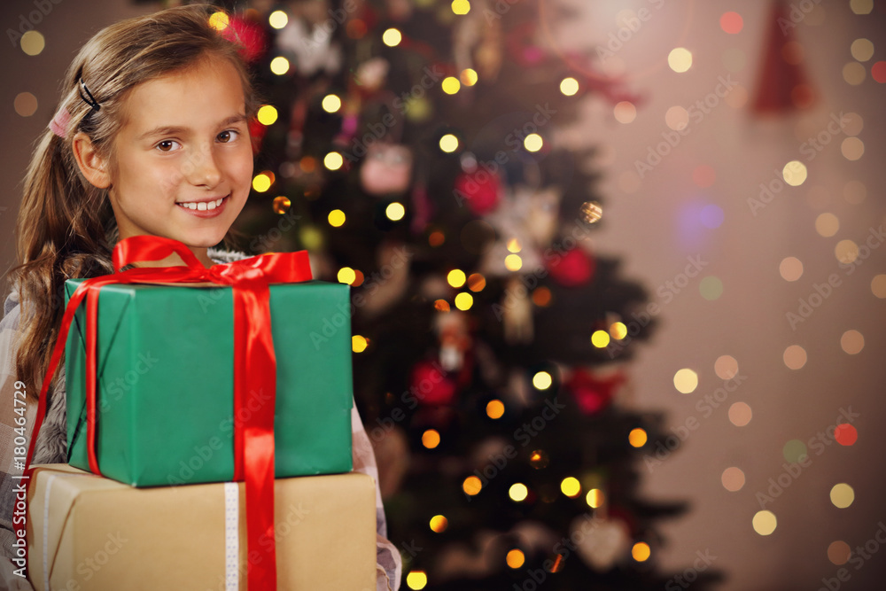 Happy girl posing with presents during Christmas time Happy girl posing with presents during Christmas time