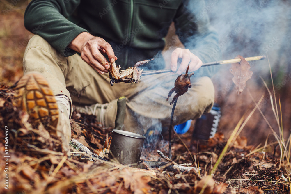 Fototapeta premium quail on the stick grilled in the fire. delicious forest picnic. bushcraft concept