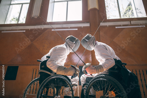 Two male disabled fencing athletes fight. men wear unbranded sports clothes