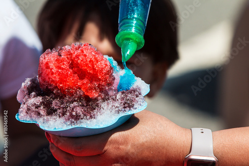 Closeup Woman Pouring Blue Syrup Onto Ice Of Snow Cone