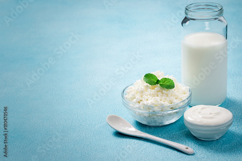Fresh milk sour cream yogurt cottage cheese in glass bowls on blue background. Selective focus, copy space.  photo