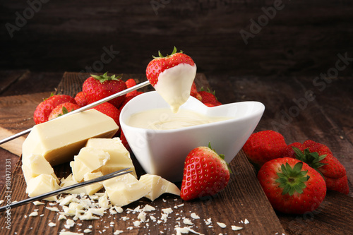 Fotografie Chocolate fondue melted with fresh strawberries and white chocolate pieces